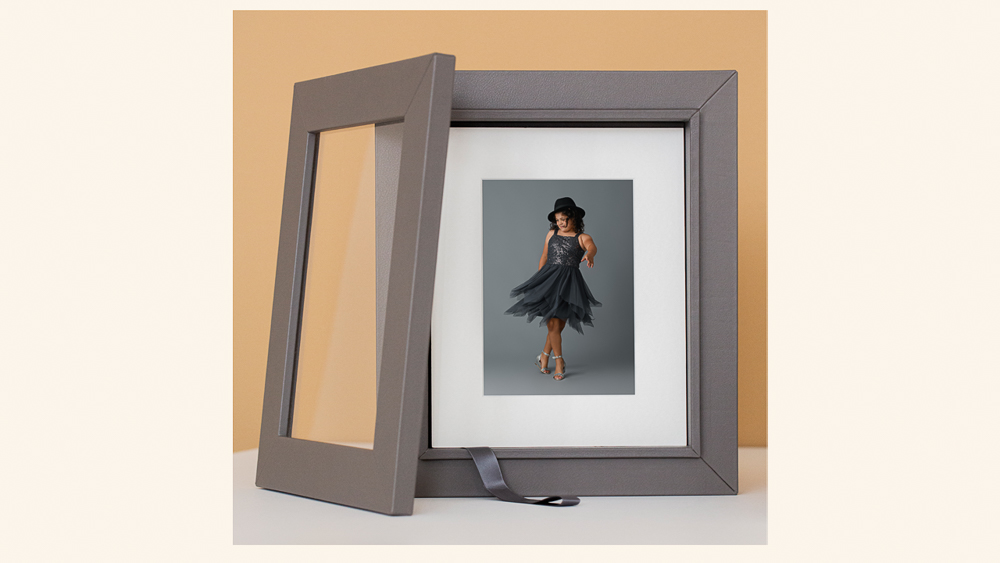 Gray portrait box displaying a portrait of a young girl twirling in a black dress in white mat | Lisa Maco Photography