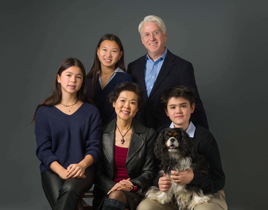 Family of five with their dog posing together during a classic studio portrait session in DC