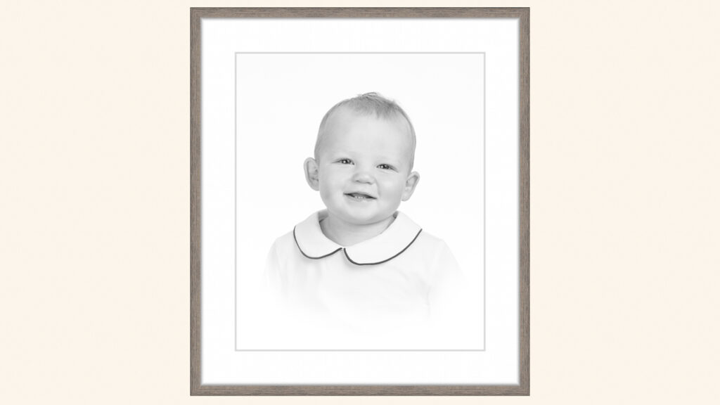 Smiling toddler in a classic black and white heirloom portrait with soft vignette framing and delicate Peter Pan collar detail | Lisa Maco Photography