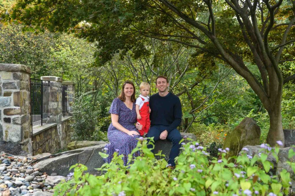 Young family posing together in a lush garden during a DC family portrait session