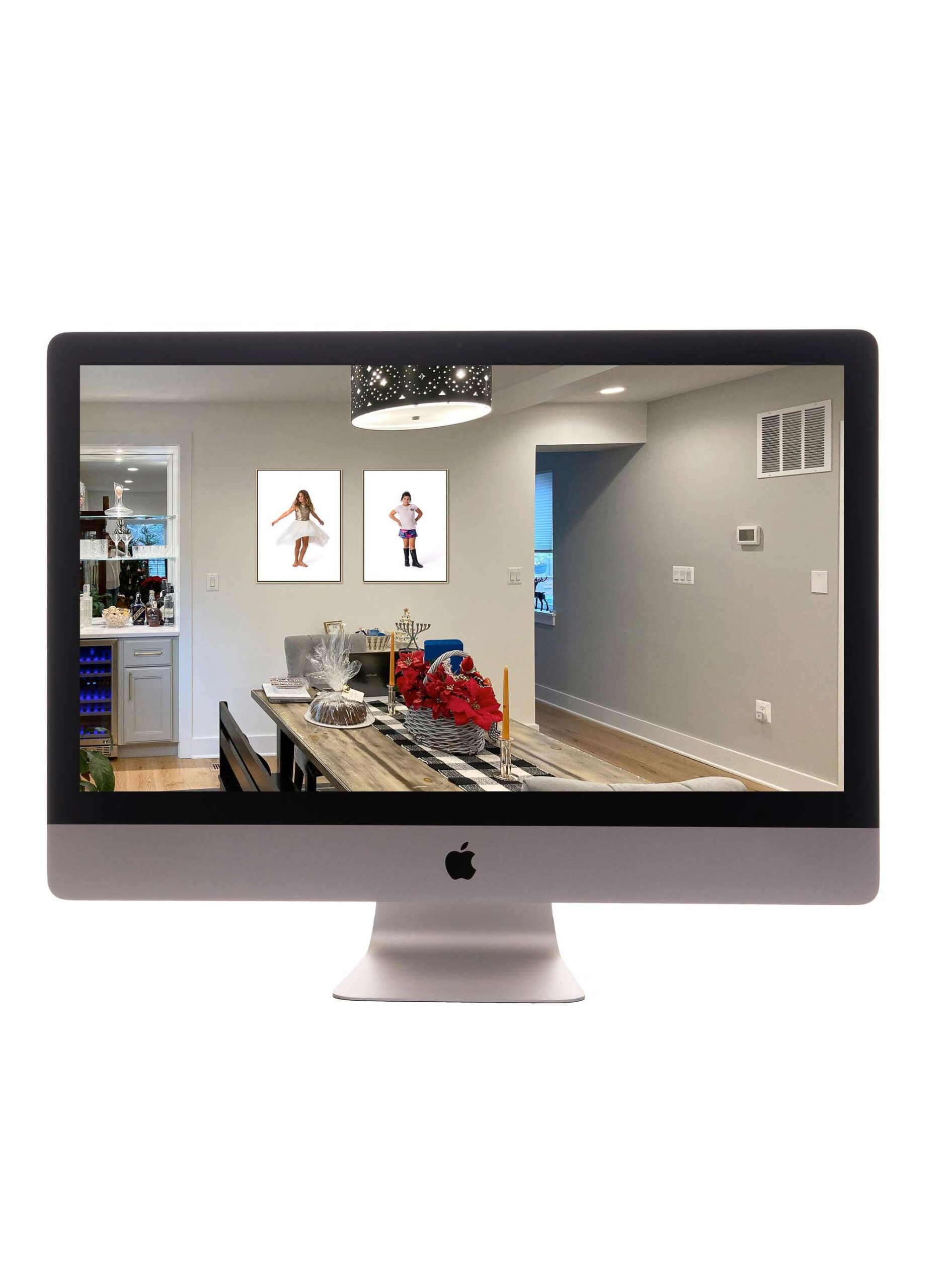 Modern kitchen and dining room with two framed portraits of children hanging above a table decorated with red flowers and home accessories