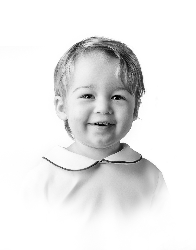 Smiling toddler in a classic studio portrait with soft lighting, exemplifying the clean and timeless style of DC family photography