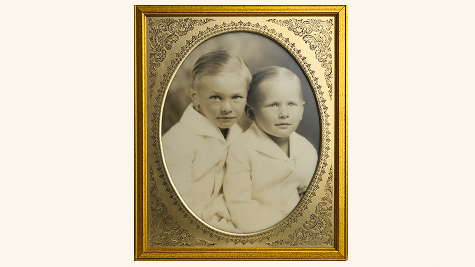 Two young boys in soft, neutral clothing pose together in this classic studio portrait, exemplifying the timeless family photography style that Lisa Maco brings to DC families
