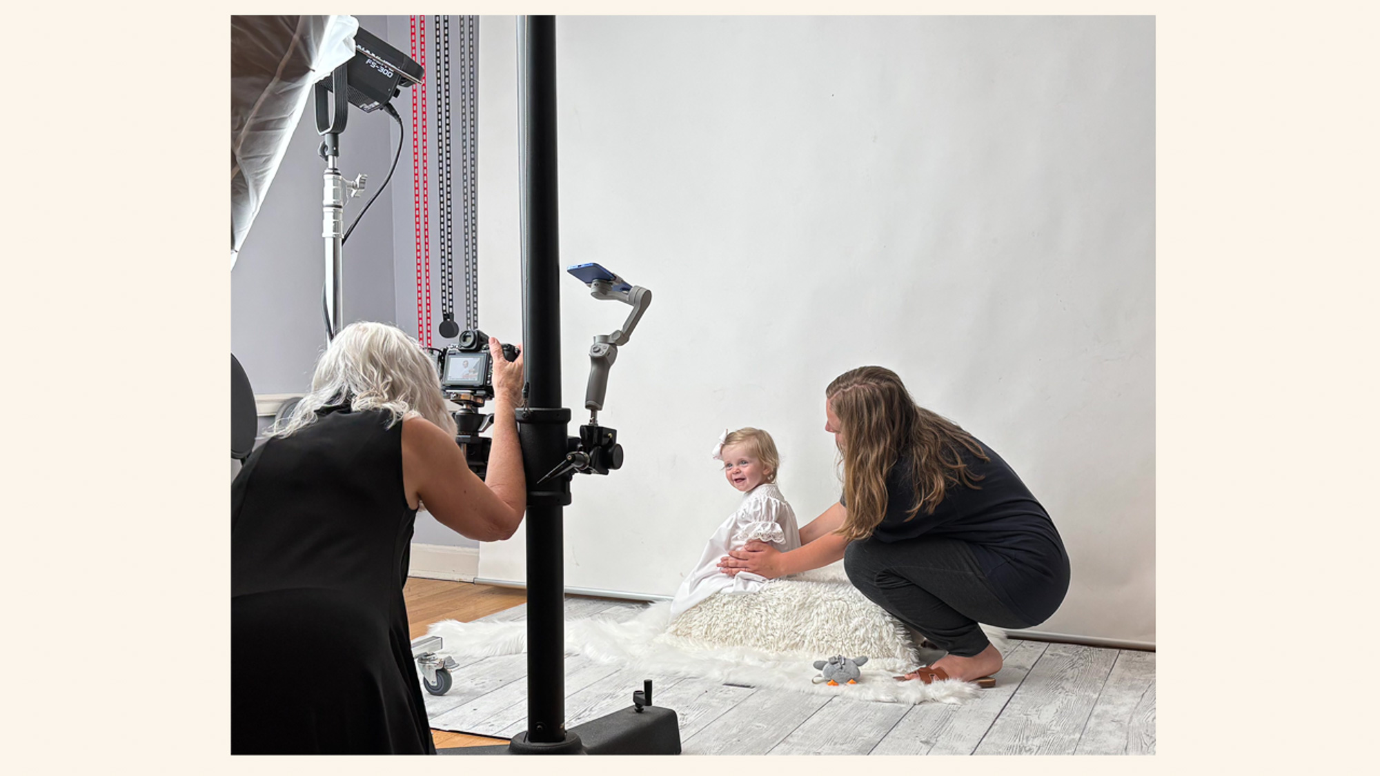 children during a studio portrait session while an adult assists with posing